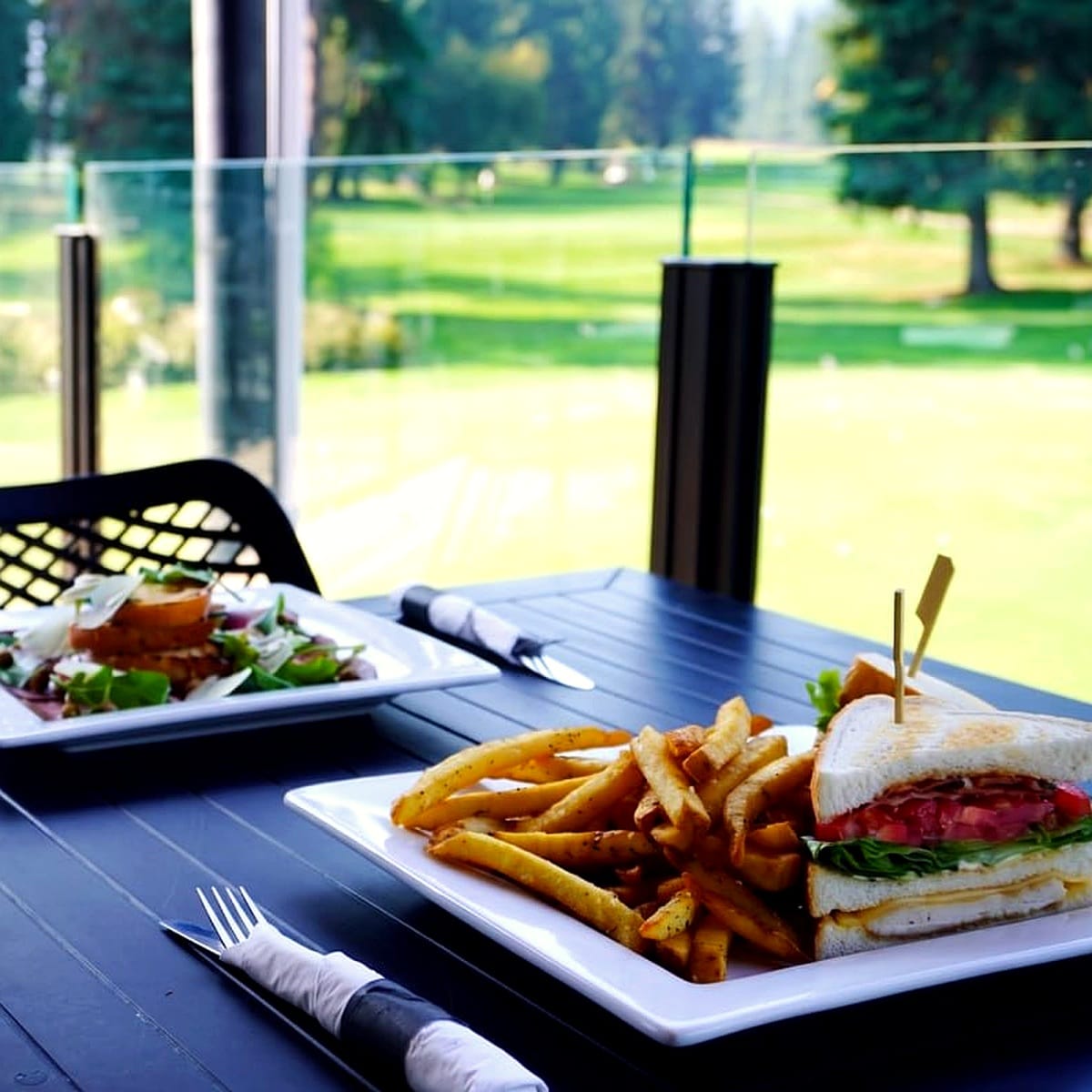 Birchbank Clubhouse triple-decker with bacon, turkey, cheddar and fries on the patio
